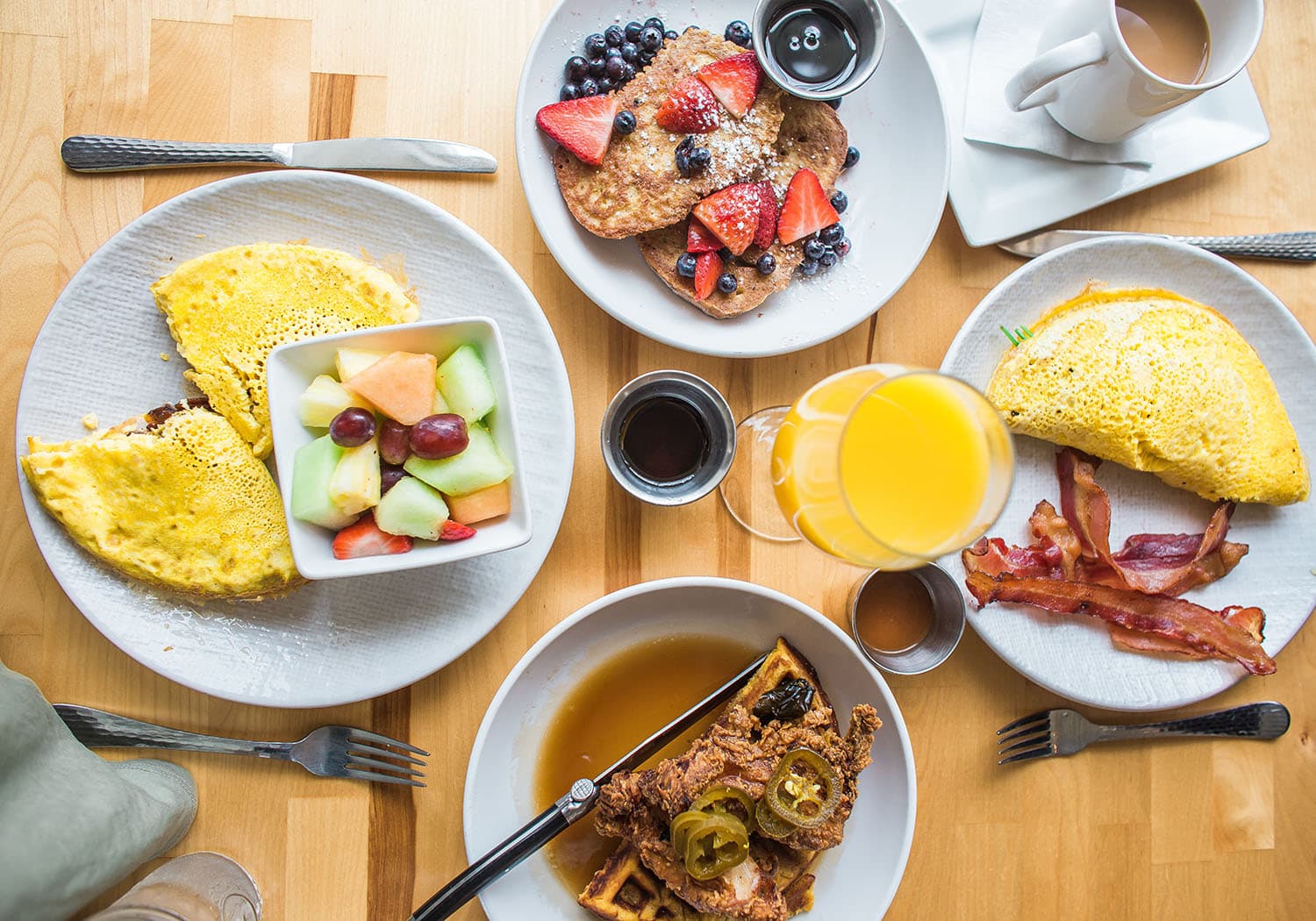 Café da manhã do Love Time Hotel, com diversos pratos e bebidas, servido em uma mesa com talheres